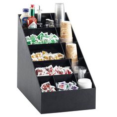 an assortment of drinks and snacks are arranged in a black organizer on a white background