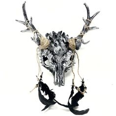 an animal skull with antlers and horns hanging from it's back end, on a white background