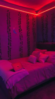 a bed in a room with pink lights on the walls