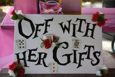 a sign that says, off with her gifts on the table next to some cards