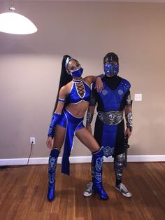 two people dressed in blue and silver standing next to each other on a hard wood floor