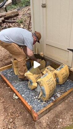 a man is working on some kind of thing in the dirt and gravel outside his house