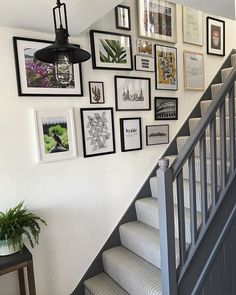 a stairway with pictures on the wall and stairs leading up to the second floor area