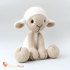 a crocheted sheep sitting on top of a white surface