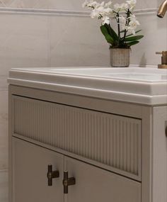 a white sink sitting under a faucet in a bathroom