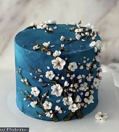 a blue cake with white flowers on it