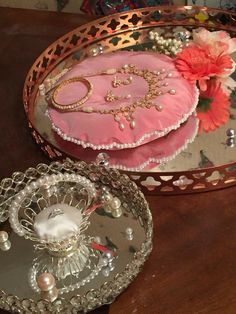 two decorative trays sitting on top of a wooden table