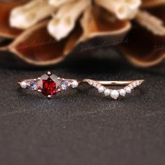 a close up of two rings on a table with flowers in the background