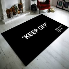 a black area rug with the words keep off on it in front of a fireplace