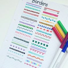 two pens are sitting next to each other on a notebook with colorful doodles in it