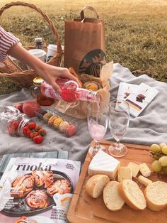 a picnic with bread, fruit and wine on the grass