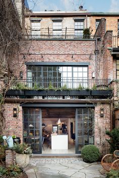 a brick building with lots of windows and plants