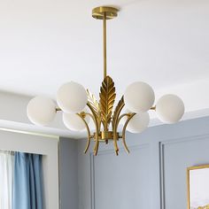 a chandelier hanging from the ceiling in a room with blue walls and curtains