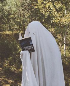 a person in a ghost costume holding a book