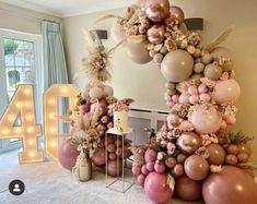 the balloon arch is decorated with pink, gold and white balloons that spell out 40