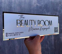 a person holding up a sign that says the beauty room