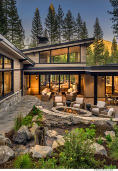 a house with a fire pit in the middle of it and lots of windows on each side