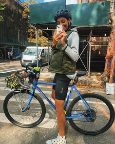 a woman taking a selfie while standing next to her bike