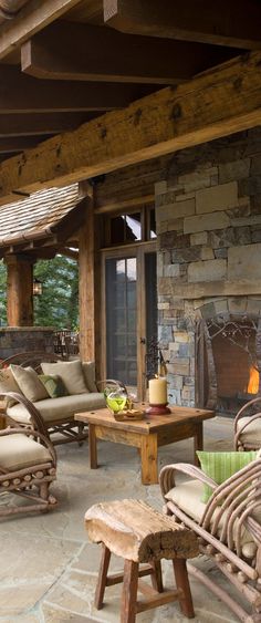 an outdoor living area with wicker furniture and stone fireplace