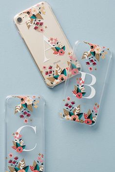 two clear cases with flowers on them next to an iphone 6s and the number six