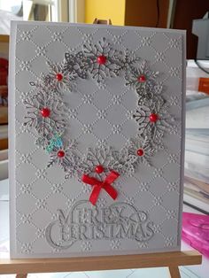 a handmade christmas card with snowflakes and holly wreaths on the front