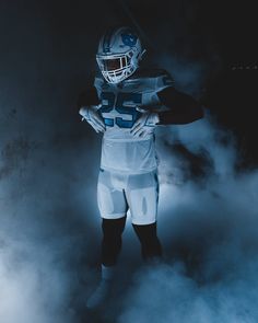 a football player is standing in the fog