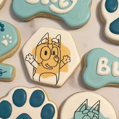 decorated cookies with blue and white icing are on a table next to each other