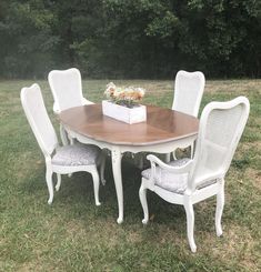 a white table and chairs in the grass