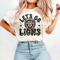 Show your Lion pride on game day in this cute retro Let's Go Tigers t-shirt!  *Please message us for youth sizes.* COMFORT COLORS DETAILS: .: Soft-washed, garment-dyed fabric  .: Double-needle stitching throughout  .: 100% ring-spun cotton .: Medium fabric (6.1 oz/yd² (206.8 g/m .: Relaxed fit .: Sewn-in twill label CARE INSTRUCTIONS: .: Machine wash cold; do not bleach. Dry on low heat or lay flat to dry; do not dry clean. SIZING .: This is a relaxed fit shirt. For a fitted look consider sizing Team Spirit Slogan Tops For Fan Gear, Team Spirit Slogan Tops For Fans, Slogan Fan Gear Tops, School Spirit Slogan Top For Game Day, Sports Fan Slogan Tops For Game Day, Game Day Sports Fan Slogan Tops, School Spirit Slogan Tops For Fan Merchandise, Retro Tops With Text Print For Game Day, Retro Game Day Tops With Text Print