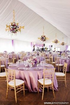 the inside of a tent with tables and chairs set up for a formal function,