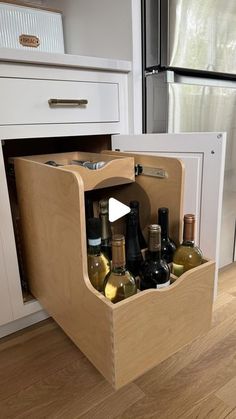 an open cabinet with wine bottles in it