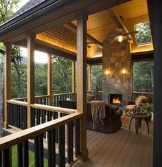 an outdoor living area with wood flooring and stone fireplace