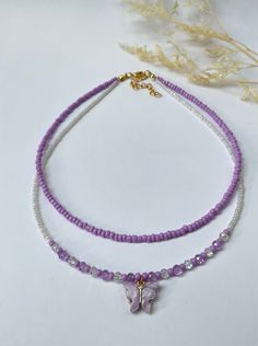 This dainty, layered necklace is beautifully crafted, and brings a whimsical touch to any outfit. Beautiful  purple-beaded necklace made with seed beads and a purple butterfly pendant. Each necklace is handmade and carefully crafted to ensure durability for everyday wear.  This two-layer necklace is attached with a crimp bead for a nice, neat look. The layers of the necklace differ by one inch in length, with an adjustable 2 inch extender chain (the size listed is for the SHORTER layer). I offer nine different lengths. If you would like a different length, please feel free to leave a message. My business thrives on Customer Satisfaction Please do not hesitate to reach me if there is something wrong with your purchase. I will try my best to make it right for you. Thank you for shopping JGBe Trendy Handmade Crystal Necklaces, Adjustable Layered Necklace As Gift, Adjustable Layered Necklace Gift, Handmade Double Strand Crystal Necklace, White Beaded Chain Layered Necklace As A Gift, White Beaded Chain Layered Necklace For Gift, Dainty Double Strand Beaded Necklaces For Layering, Trendy Adjustable Layered Necklace Gift, White Layered Necklace With Beaded Chain For Gift