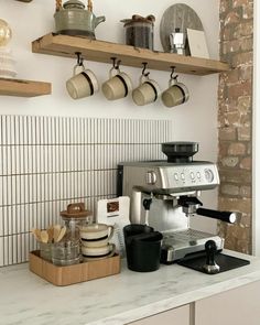 a coffee maker sitting on top of a kitchen counter next to pots and pans