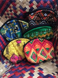 four purses sitting on top of a woven basket