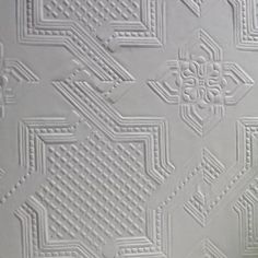 a close up view of a white textured wallpaper with an intricate design on it