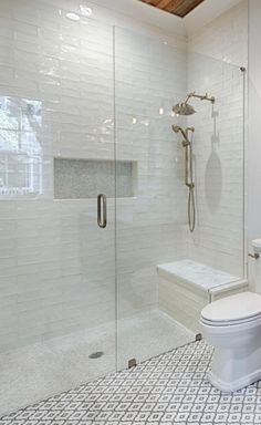 a white toilet sitting next to a walk in shower