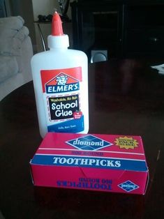 a bottle of toothpaste sitting on top of a table next to a box