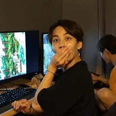 two people sitting in front of computer monitors