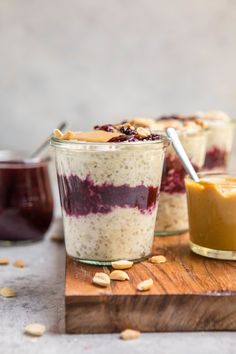 three jars filled with oatmeal sitting on top of a wooden cutting board