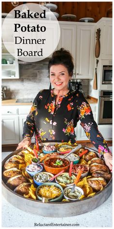 a woman standing in front of a large platter filled with different types of food