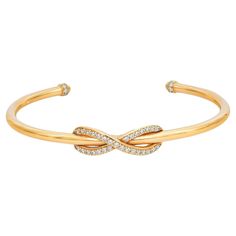 Gorgeous and elegant, Tiffiany & Co. Infinity Diamond Cuff Bracelet exudes sophistication. Stunningly crafted in lustrous 18K yellow gold. It features a cuff style bangle bracelet with a center infinity design studded with round brilliant cut diamonds in pave setting. Total diamond weight: 0.39 carat. Size: Medium. The total wrist fit is up to 6.5 inches. Total weight: 17.92 grams. Super stackable and easy to wear. Comes with a Tiffany box. Tiffany And Co Bracelet, Diamond Cuff Bracelet, Tiffany Box, Infinity Design, Tiffany And Co, Round Brilliant Cut Diamond, Tiffany & Co., Cuff Bracelet, Cuff Bracelets