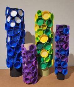 three different colored vases sitting on top of a wooden table next to each other