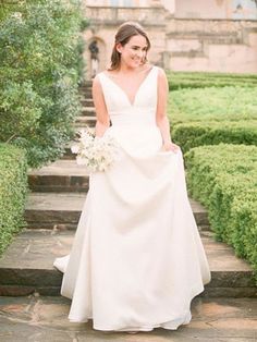 a woman in a wedding dress standing on some steps