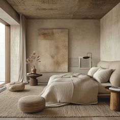 a bedroom with a large bed and lots of pillows on the floor in front of a window