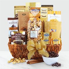 a gift basket filled with nuts, chocolates and other snacks on a white table