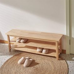 a wooden bench sitting on top of a rug next to a wall mounted shoe rack