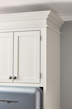 a refrigerator freezer sitting inside of a kitchen next to a white cabinet with doors