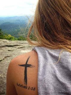 a woman with a cross tattoo on her arm and the words, for i have been crucified with christ and no longer live, but christ lives in me