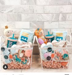 two baskets filled with stuffed animals sitting on top of a marble counter next to each other